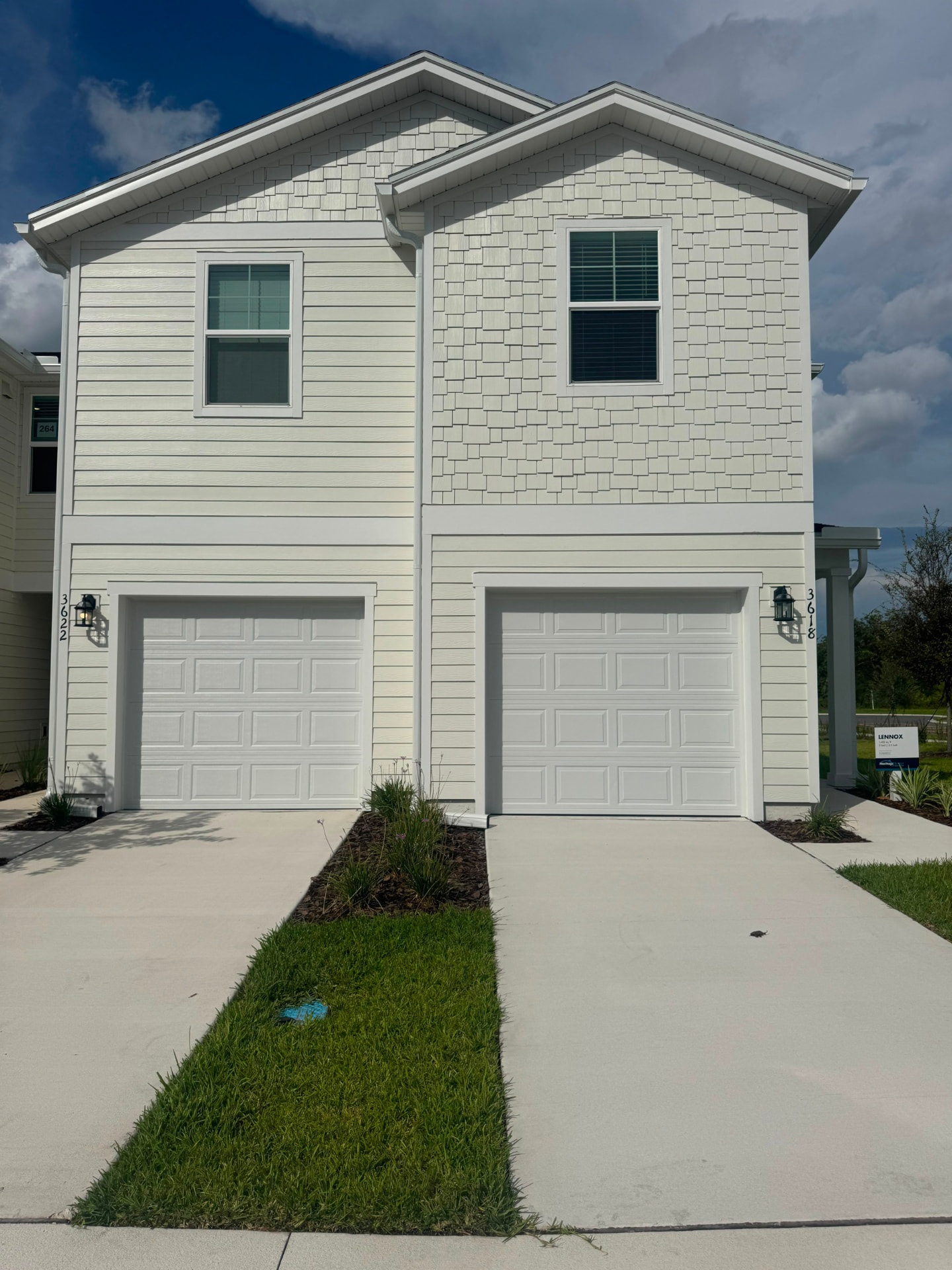Brand new two-story townhomes with white siding and two-car garages